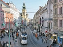 Belebte Stadtstrasse mit Strassenbahn und historischen Gebäuden.