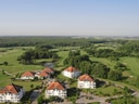 Luftaufnahme von Gebäuden und einem Golfplatz mit viel Grün.
