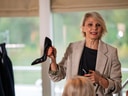 Frau hält schwarzen Schuh bei Präsentation.