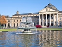 Brunnen vor dem historischen Gebäude mit Kuppel und Säulen.