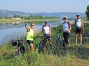 Fahrradfahrergruppe posiert am Flussufer.