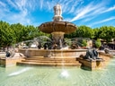 Grosser Springbrunnen mit Löwenfiguren und Himmel im Hintergrund.