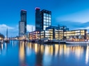 Moderne Gebäude bei Nacht mit reflektierendem Wasser.