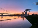 Brücke und Schiffsrumpf bei Sonnenuntergang am Fluss.