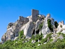 Ruinen einer Burg auf einem Felsen unter blauem Himmel.