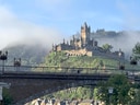 Reichsburg Cochem auf Hügel mit Nebel.