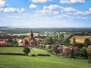 Landschaft mit Kirche und Bauernhöfen auf dem Land.