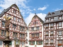 Fachwerkhäuser mit Brunnen und blauer Himmel.