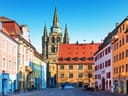 Historische Gebäude mit Turm und blauem Himmel im Hintergrund.