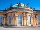 Barockgebäude mit grossen Fenstern und dekorativen Skulpturen.