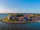 Luftaufnahme eines Küstenortes mit Hafen am Meer.