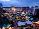 Luftaufnahme eines Weihnachtsmarktes mit zahlreichen Ständen und Lichtern.