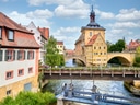 Historisches Gebäude auf Brücke mit Fluss, Altstadt Hintergrund.