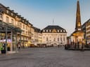 Historischer Stadtplatz mit Pflastersteinen, Gebäuden und einem Obelisken.