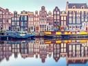 Bunte Häuser und Boote am Kanal in Amsterdam.