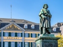 Statue vor historischem Gebäude mit gelben und weissen Fassaden.