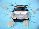 Trabant bricht durch blaue Wandmalerei.