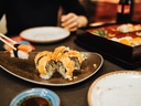 Nahaufnahme von Sushi auf Tisch mit Essstäbchen.
