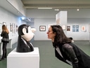 Frau betrachtet Skulptur in einer Kunstgalerie.