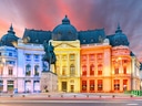 Beleuchtetes historisches Gebäude mit Statue bei Sonnenuntergang.