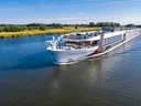 Kreuzfahrtschiff auf einem Fluss bei klarem Himmel.