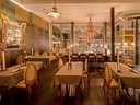Elegantes Restaurant mit Kronleuchter und gedeckten Tischen.
