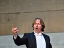 Mann in Frack singt auf der Bühne.