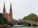 Tram auf Brücke vor Kirche in Strassburg.