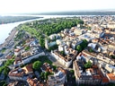 Luftaufnahme einer Stadt mit Fluss und grünen Parks.