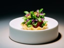 Gourmetgericht auf weissem Teller präsentiert.