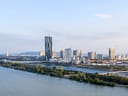Stadtansicht von Wien mit Donauturm am Flussufer.