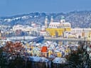 Schneebedeckte Stadt mit Fluss und Brücke im Winter.
