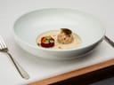 Schüssel mit elegant angerichtetem Gourmetgericht, Gabel links.