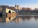 Brücke über einen Fluss mit historischem Gebäude im Hintergrund.