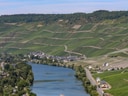 Fluss mit Booten und umliegenden Hügeln.