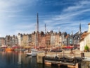 Hafen mit bunten Gebäuden und Segelschiffen.