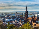 Panoramablick auf Freiburg mit Münster und Landschaft im Hintergrund.
