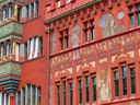 Rotes Gebäude mit Wandmalereien und Ornamenten.