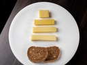 Käsestücke und Brotscheiben auf weissem Teller.