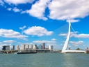 Moderne Hängebrücke mit Skyline im Hintergrund.
