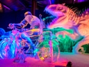 Beleuchtete Eisskulpturen von Motorradfahrer und Dinosaurier.