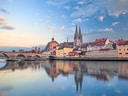 Mittelalterliche Stadtansicht mit Fluss und Brücke.