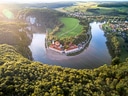 Luftaufnahme von Benediktinerkloster bei Flussbiegung in grüner Landschaft.