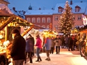 Weihnachtsmarkt mit Ständen und beleuchtetem Weihnachtsbaum.