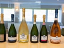Sechs Flaschen Champagner auf einer Theke in einem eleganten Raum.