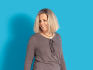 Person mit blondem Haar vor blauem Hintergrund.