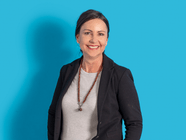 Frau in schwarzem Blazer vor blauem Hintergrund.