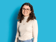 Person mit Brille und lockigem Haar vor blauem Hintergrund.