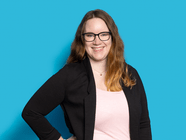 Person mit Brille vor blauem Hintergrund lächelt.