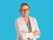 Person mit Brille und hellem Blazer vor blauem Hintergrund.